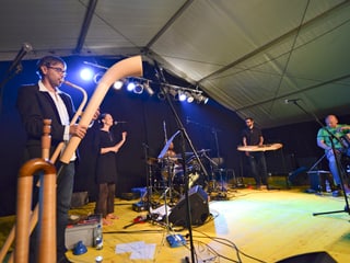 Ein Mann mit einem Alphorn und andere Musiker auf der Bühne. Ein Mann mit einem Alphorn und andere Musiker auf der Bühne.