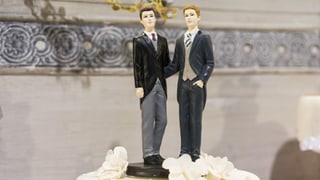 Zwei Marzipan-Männerfiguren auf einer Hochzeitstorte