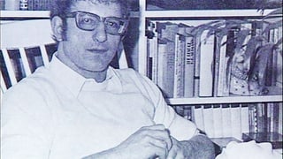 Portrait von Fritz Mars vor seinem Bücherregal.