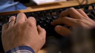 Hände auf einer Computertastatur.