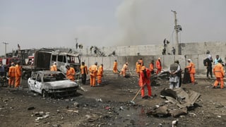 Helfer räumen die Strasse nach einem Anschlag in Kabul. Helfer räumen die Strasse nach einem Anschlag in Kabul.