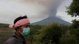 Vulkan Agung bedrohlich nahe: Ein Dorfbewohner von Karangasem schützt sich mit einer Maske 