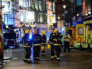 Feuerwehrleute auf einer Strasse.
