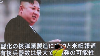 Ein Passant steht vor einem grossen Fernsehschirm mit dem Bild von Kim Jong-un.