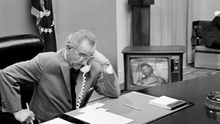 Lyndon B. Johnson telefoniert an seinem Schreibtisch.