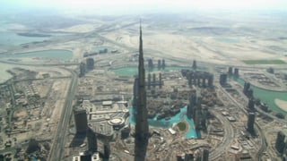 Eine Luftaufnahme zeigt den Burj Khalifa neben vielen kleinen Häusern in Dubai.