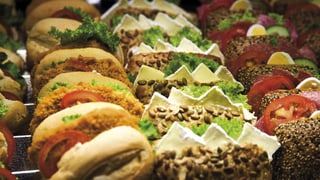 Auslage mit verschiedenen Sandwiches, mit diversem Fleisch, Käse und Gemüse belegt.