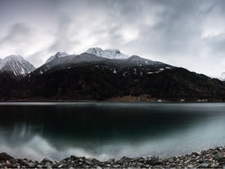 Ein See und ein Berg dahinter, dessen Spitze eingeschneit ist.