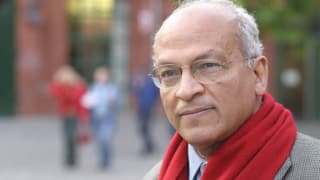 Gamal al-Ghitani trägt einen roten Schal und eine randlose Brille. 