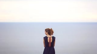 Eine Frau vor einem weiten Horizont mit Meer