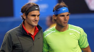 Zu sehen sind die beiden Tennisspieler Roger Federer und Rafael Nadal vor einem Tennisspiel. Sie stehen nebeneinander und sind noch nicht verschwitzt.