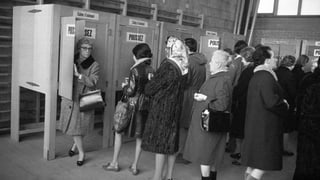 Frauen geben ihre Stimme in einer Wahlkabine ab Frauen geben ihre Stimme in einer Wahlkabine ab