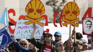 Protestierende halten Schilder, die das Shell-Logo als Totenkopf zeigen. 