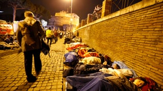 Menschen in Schlafsäcken auf einer Strasse
