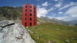 ein roter Turm in der Berglandschaft