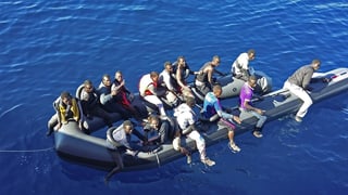 Symbolbild: 15 Afrikaner auf einem offenbar langsam sinkenden Gummiboot auf dem Meer.
