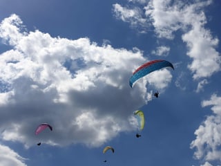 Himmel mit ein paar Wolken und 4 Gleitschirmen. 
