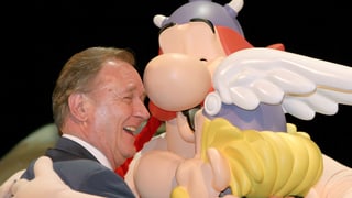 Albert Uderzo umarmt Asterix und Obelix. 