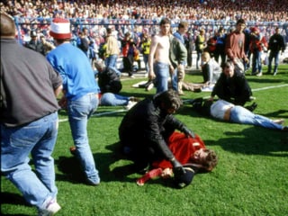 Fans auf dem Spielfeld neben Toten und Verletzten.