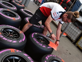 Ein Mechaniker markiert Formel-1-Reifen