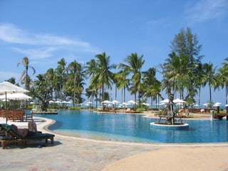 Eine Hotelanlage mit Swimmingpool und Palmen