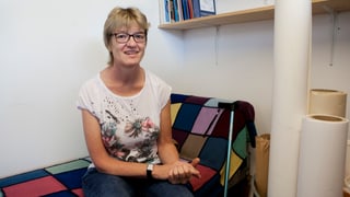 Eine Frau sitzt auf einem Sofa. Eine Frau sitzt auf einem Sofa.