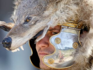 Ein Mann in einem Gladiatorkostum mit Wolfshelm. 