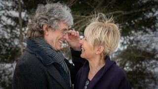 ein älteres Paar schaut sich in die Augen und lächelt sich an