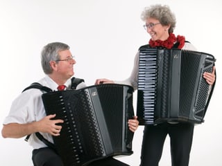 Frau und Mann spielen Piano-Akkordeon.