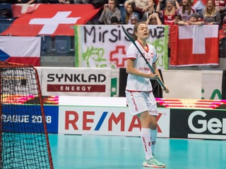 Unihockeyspielerin Isabelle Gerig steht neben dem Tor, im Hintergrund Schweizer Fans.