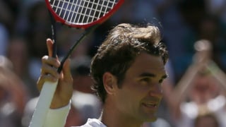 Roger Federer winkt mit dem Racket den Fans zu.