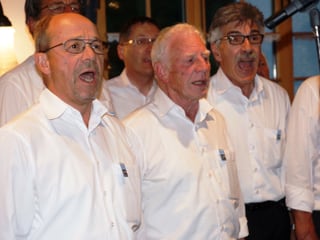 Eine Gruppe von Sängern in weissen Hemden beim Singen.
