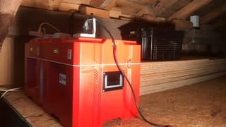 Rote Power-Blox-Würfel im Dachstock einer Holzhütte (Alphütte)