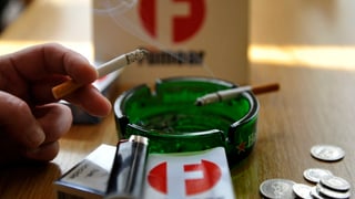 Aschenbecher mit Zigaretten im Hintergrund Fümaor-Logo