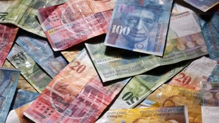 Schweizer Geldnoten liegen auf einem Tisch.