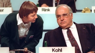 Merkel beugt sich zu Helmut Kohl.