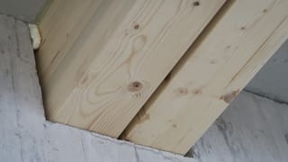 Holzbalen verschwinden in die Betonmauer. Holzbalen verschwinden in die Betonmauer.