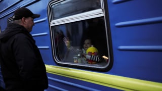 Ein fliehendes Mädchen winkt einem Verwandten zu, der, wehrpflichtig, die Ukraine nicht verlassen darf (Symbol).