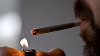 Mann zündet sich einen Joint an Mann zündet sich einen Joint an