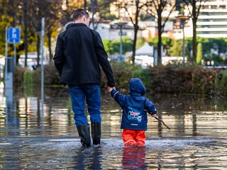 Mann mit Kind im Hochwasser