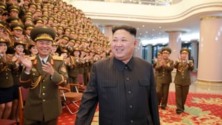 Der nordkoreanische Diktator Kim Jong Un, dahinter viele Sänger in Uniform