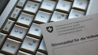 Auf einer Computertastatur liegt ein Stimmzettel für die Volksabstimmung Auf einer Computertastatur liegt ein Stimmzettel für die Volksabstimmung