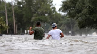 Zwei Menschen stehen hüfthoch im Wasser Zwei Menschen stehen hüfthoch im Wasser