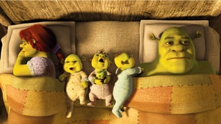 Ein grünes Sumpfmonster-Ehepaar liegt im Ehebett. Zwischen ihnen liegen drei unruhige grüne Sumpfmonster-Babies.