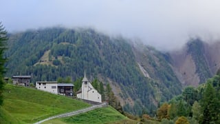 Kirche in bBnn/VS, darüber tiefe Wolken den Berghängen entlang. Kirche in bBnn/VS, darüber tiefe Wolken den Berghängen entlang.
