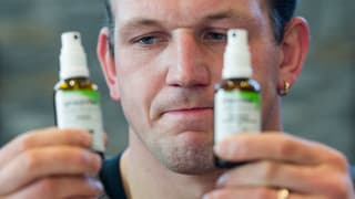 Bruno Gisler hält zwei Sprays in der Hand.