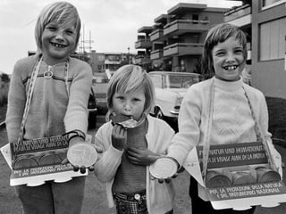 Drei Kinder ziehen durch die Strasse mit Bauchladen voller Schoggitaler. Drei Kinder ziehen durch die Strasse mit Bauchladen voller Schoggitaler.