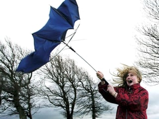 Der Wind reisst den Schirm aus der Hand eines Mädchens. Der Wind reisst den Schirm aus der Hand eines Mädchens.