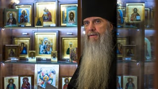 Bischof der Russisch-Orthodoxen Kirche mit langem Bart vor Heiligenbildchen.