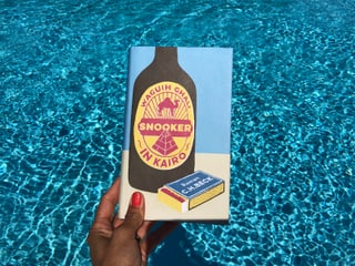 Annette König hält das Buch von Waguih Ghali: «Snooker in Kairo» vor blaues Wasser Annette König hält das Buch von Waguih Ghali: «Snooker in Kairo» vor blaues Wasser
